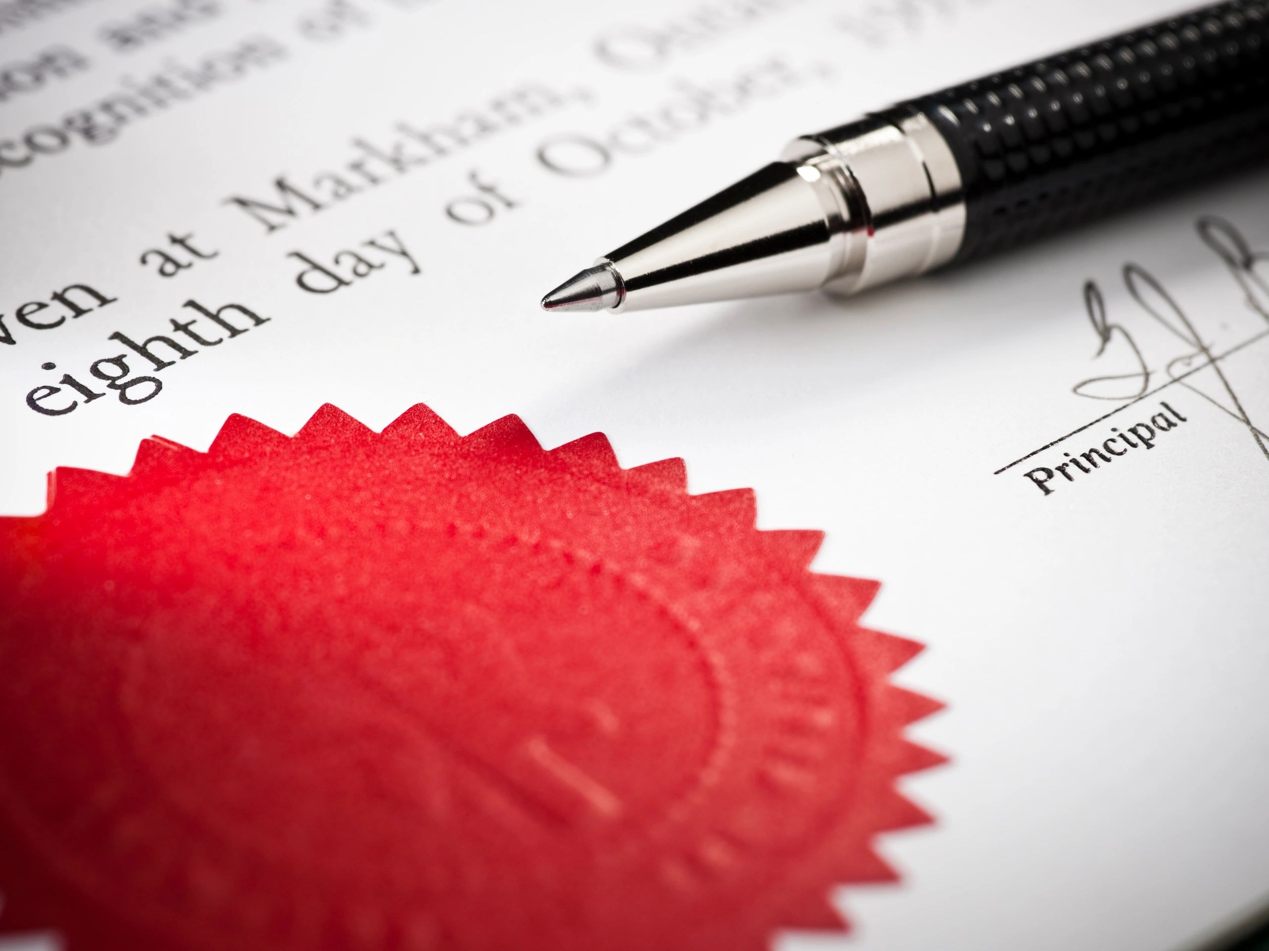 Professional document with red wax seal and pen