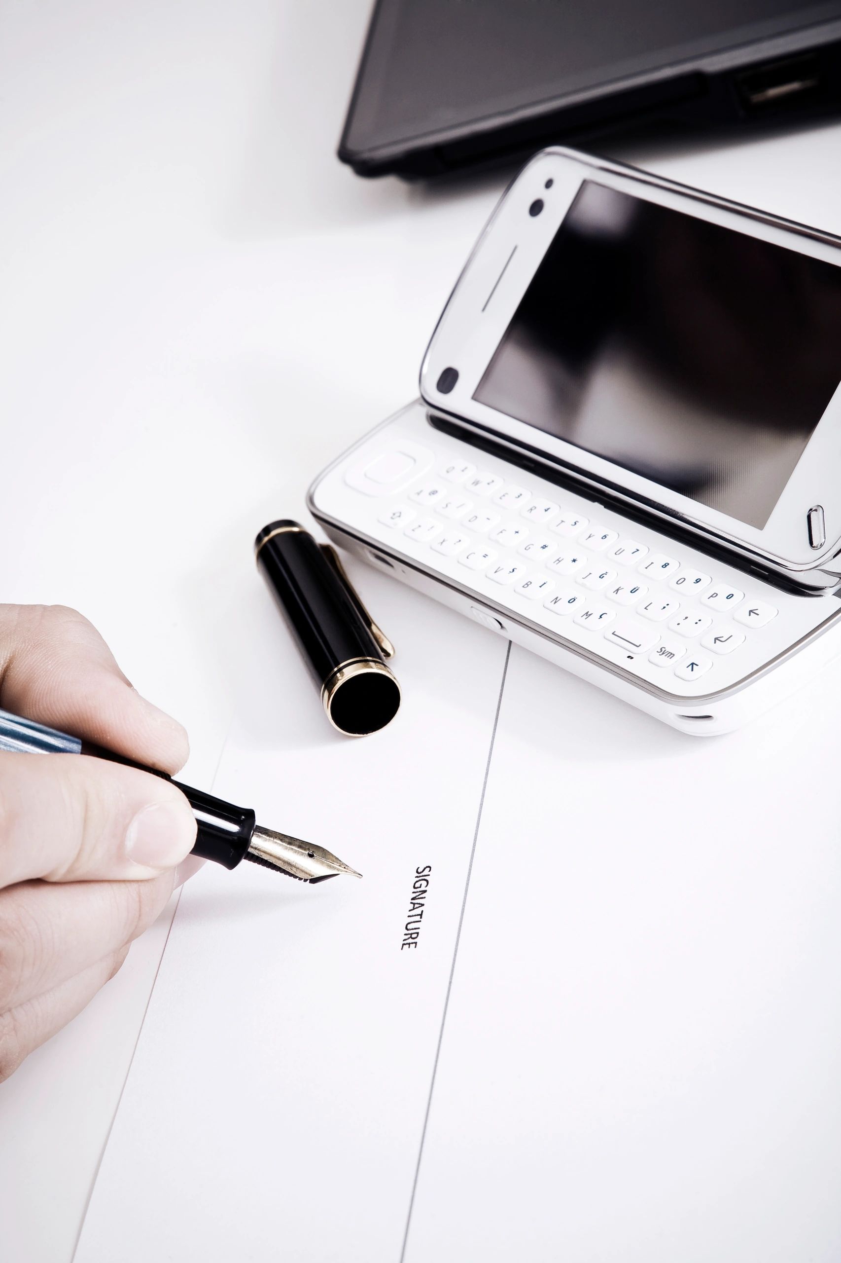 Hand signing document with pen